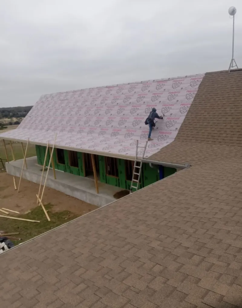 Worker preparing underlayment for a metal roof installation in Fort Hood